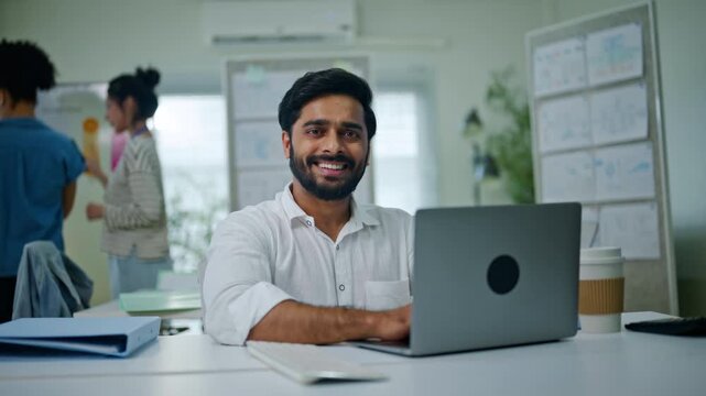 portrait of Indian businessman happy and smile with pride, about us or confident compliance agent in a modern office setting.smile and professional in company for career ambition as policy officer