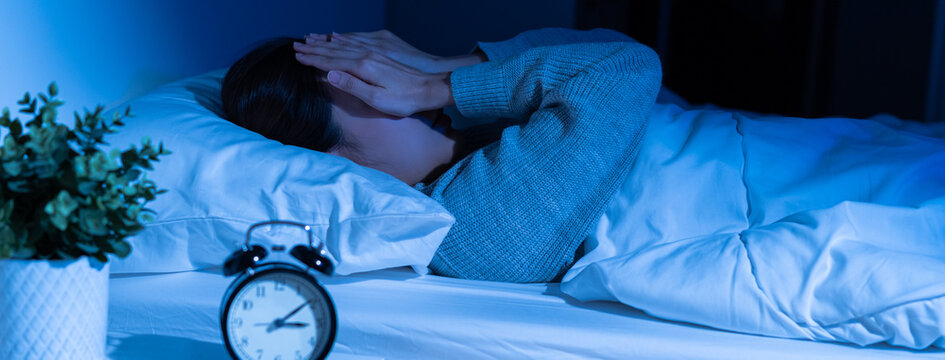Annoyed, stressed, anxiety asian young woman suffering from insomnia, frustrated awake on bed at night, headache or migraine, health care problem, disturbed trouble of loud noise, unable sleepless.