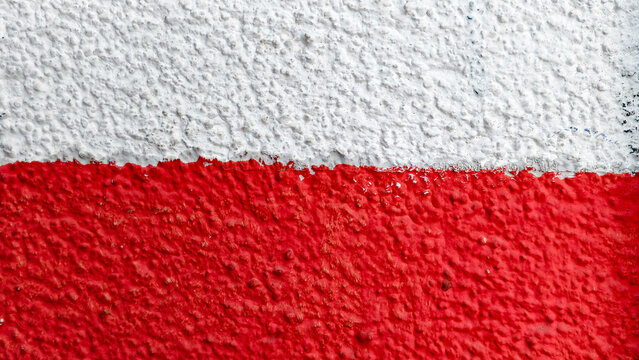 Polish flag colors painted on a rough, textured wall creating a grunge aesthetic, symbolizing national identity, patriotism, and sovereignty with a distressed, abstract background