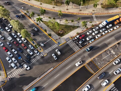 Aerial view of Avenida John F. Kennedy featuring heavy traffic on a multi-lane highway with palm trees and urban infrastructure in Santo Domingo, Distrito Nacional, Dominican Republic.