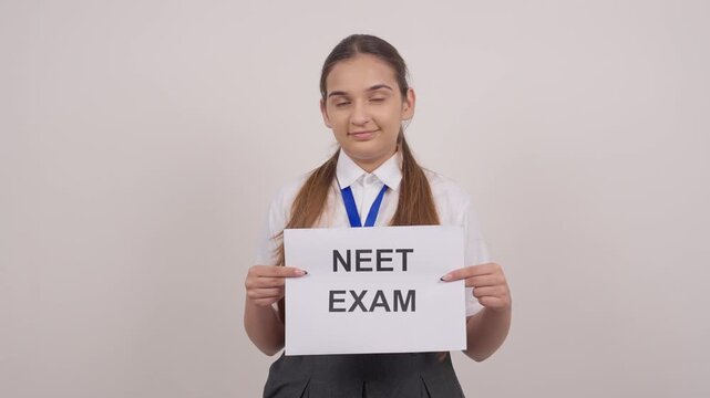 Happy Indian Schoolgirl Standing with NEET EXAM Poster