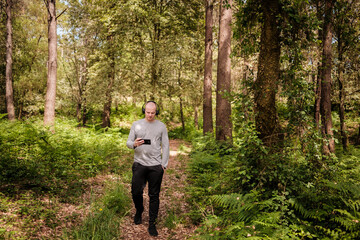 Man wearing headphones walking on forest trail © Digito  Pitoresco
