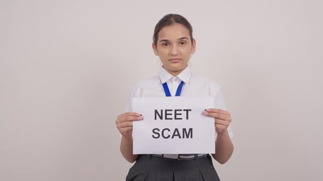 Disappointed Indian Schoolgirl Standing with NEET SCAM Poster