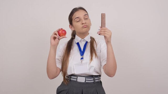 Indian Schoolgirl Choosing Between a Fresh Apple and a Chocolate Bar