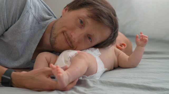 Father listening to his baby son's belly with closed eyes and natural sound.
