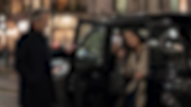 Blurred background of a couple getting out of a taxi at night