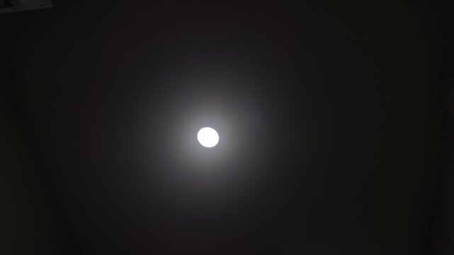 A single bright white light glowing in the center of a dark background.