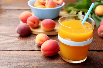 Apricot juice in glass, fresh fruits and leaves on wooden table, closeup © New Africa
