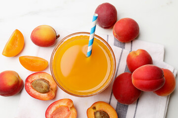 Apricot juice in glass and fresh fruits on white marble table, flat lay © New Africa
