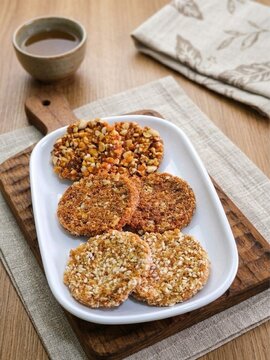 Crispy traditional Javanese enting enting, delicious combination of roasted peanuts, sesame seeds, and brown sugar on a white plate, perfect for culinary stock photos