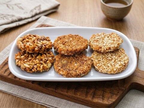 Crispy traditional Javanese enting enting, delicious combination of roasted peanuts, sesame seeds, and brown sugar on a white plate, perfect for culinary stock photos