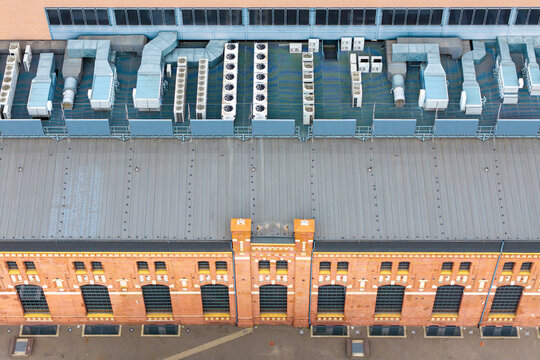 Aerial view of a renovated office building featuring a brick facade and a roof equipped with advanced ventilation systems in Poland.