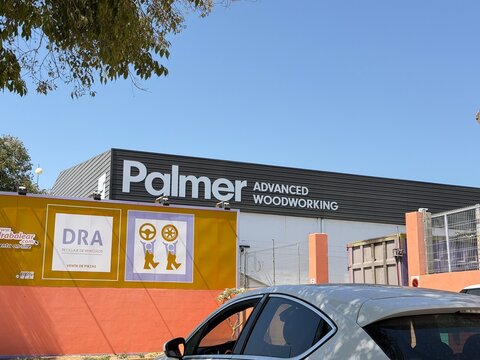 Palma, spain, august 2, 2026, palmer advanced woodworking building facade and dra vehicle recycling facility under clear blue sky