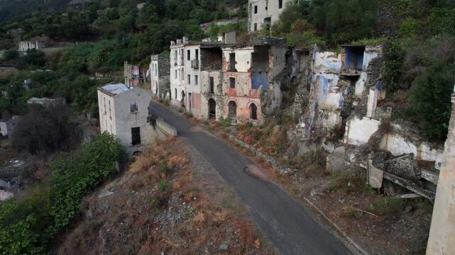 Aerial view flying over the desolate, ruined houses and empty streets of Gairo Vecchio, an abandoned ghost town in Sardinia, Italy