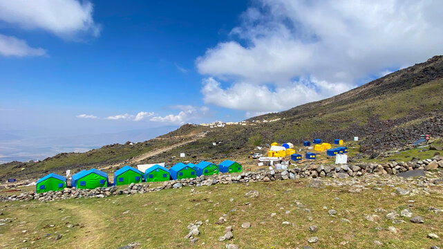 Clouds cross Ararat base camp, wide view of tents on a rocky slope at 3,300 meters in eastern Turkey