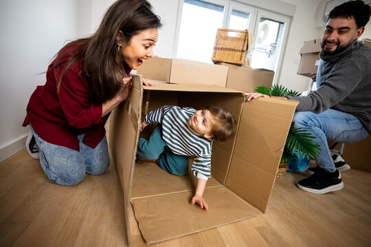 Family playing together around a cardboard box with their young son