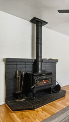 Naklejka premium Wood stove in a modern living room with brick hearth