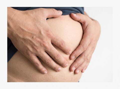 Man holding bloated stomach with both hands
