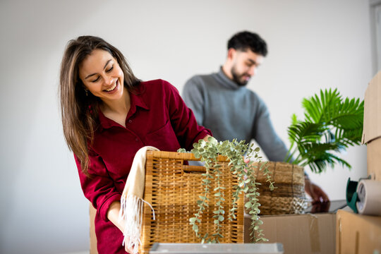 Woman carrying a wicker basket with a plant during a home move