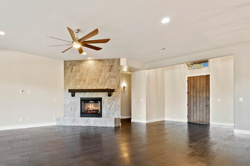 Naklejka premium Spacious living room with stone fireplace and ceiling fan