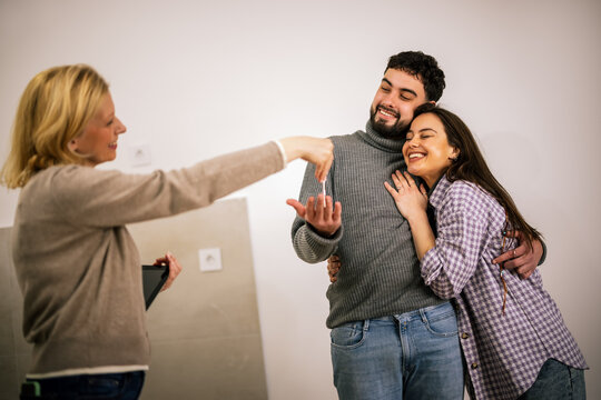 Couple receiving a house key during property handover