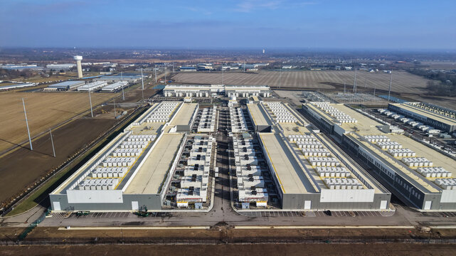 Aerial view of a large-scale data center facility with rows of cooling units on the roof, surrounded by open fields and industrial infrastructure in Dublin, Ohio, United States.