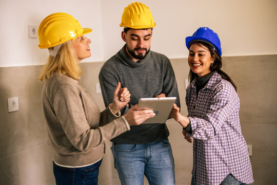 Construction professionals discussing renovation plans with a tablet