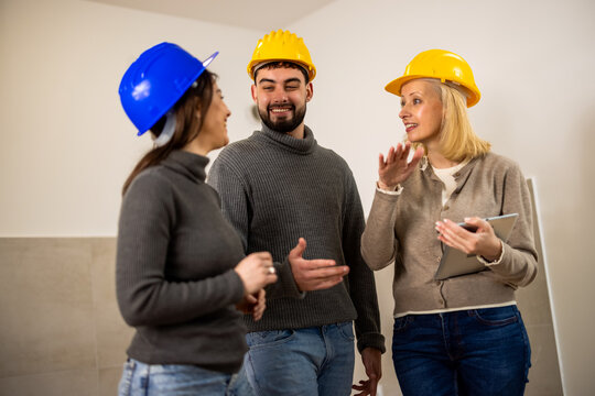 Construction professionals discussing renovation work in an unfinished room