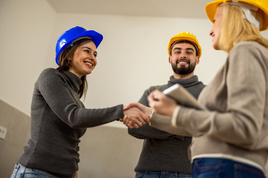 Construction professionals shaking hands and celebrating project cooperation