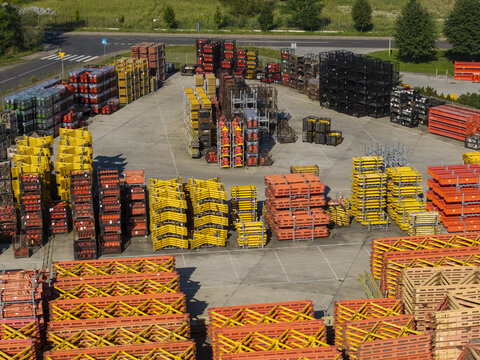 Aerial view of PERI Polska Sp. z o.o. construction equipment yard with stacks of yellow and orange formwork panels and metal scaffolding components in Jaworzno, Wojewodztwo slaskie, Poland.