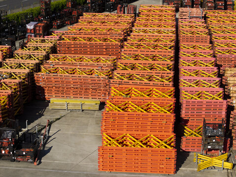 Aerial view of PERI Polska Sp. z o.o. industrial yard with stacks of orange and yellow construction formwork and scaffolding components in Jaworzno, Wojewodztwo slaskie, Poland.