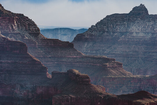 Grand Canyon Rock Formations with Hazy Blue Depth and Layered Cliffs, Arizona Landscape