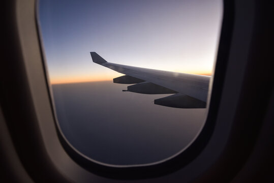 Traveling by Plane During Sunset with Cloudscape and Ocean