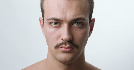 Fototapeta premium Frontal Studio Portrait of Young Man with Mustache and Intense Expression