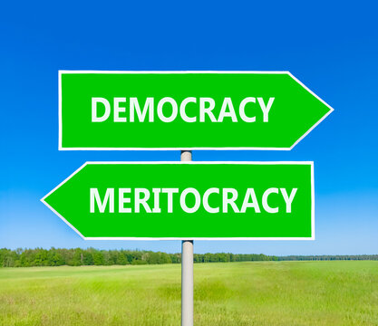 Democracy or meritocracy words symbol. Concept words Democracy Meritocracy on beautiful green road sign. Beautiful blue sky background. Business democracy meritocracy concept. Copy space