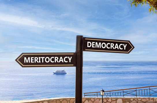 Democracy or meritocracy words symbol. Concept words Democracy Meritocracy on beautiful black road sign. Beautiful blue sky background. Business democracy meritocracy concept. Copy space