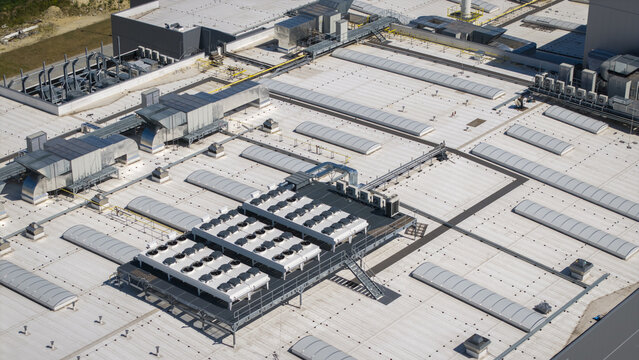 Aerial view of an AI data center cooling system featuring large HVAC units, ventilation ducts, and skylights on a flat industrial roof in Krakow, Lesser Poland Voivode, Poland.