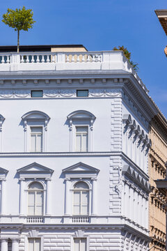 Low angle view of white classic neoclassical building facade with ornate windows against clear blue sky