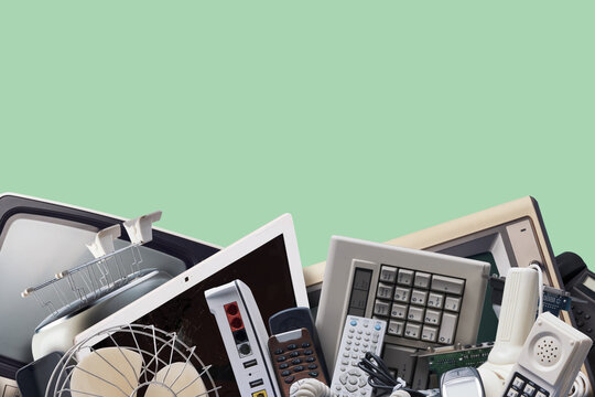 Electronic Waste Heap Concept with Discarded Tech Devices over Green Background