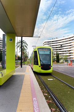 Green tram arriving at a station in murcia, spain, facilitating urban mobility