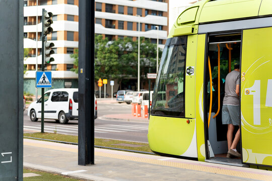 Murcia tram stopping at platform, passengers commuting in city