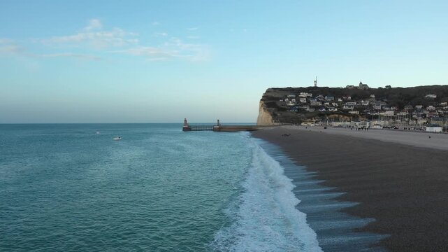 Wide view of the pebble beach and dramatic white cliffs at Fecamp, Normandy, France. The footage captures the characteristic landscape of the Alabaster Coast in northern France.