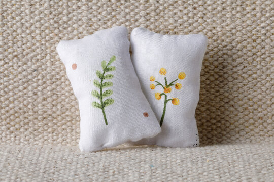 White pillows with little plants on sofa
