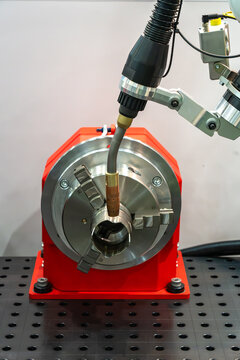 Industrial CNC machining setup with precision tool head, metal component and rotary chuck on a machine table, modern manufacturing equipment for automated machining and engineering