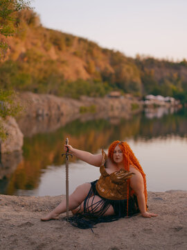Plus Size Redhead Warrior Woman Resting by Lake Holding Sword