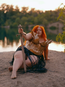 Plus Size Redhead Warrior Woman Resting by Lake Holding Sword