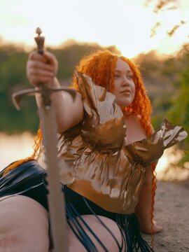 Plus Size Redhead Warrior Woman Resting by Lake Holding Sword