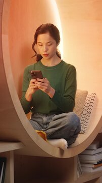 Excited Korean woman reads good news message on phone, celebrating success