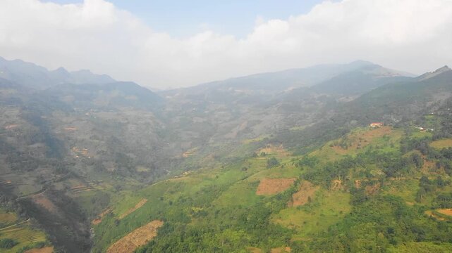 A wide aerial view over the lush green mountains and valleys of Bac Ha, located in the Lao Cai province of northern Vietnam.