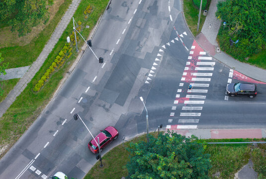 Aerial view of Plac Zebran Ludowych intersection with a pedestrian crossing, cars, and surrounding green spaces in Gdansk, Pomeranian Voivodeship, Poland.